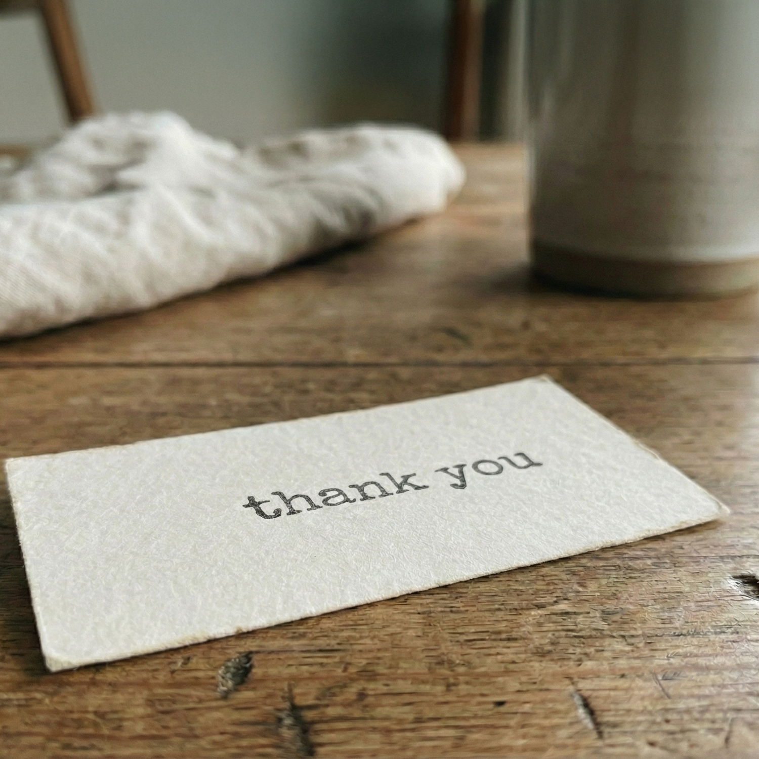 Note with 'thank you' on a wooden surface