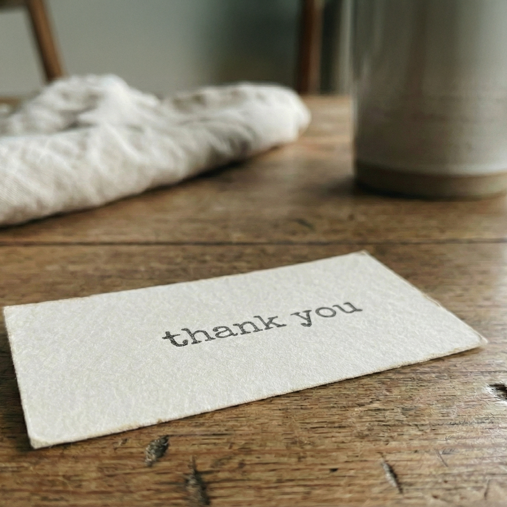 Note with 'thank you' on a wooden surface
