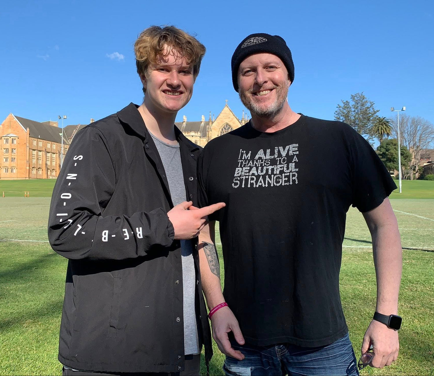 Jayden, founder of Survivor Collective, standing outdoors with his son Henry, taken two years after Jayden’s heart transplant.